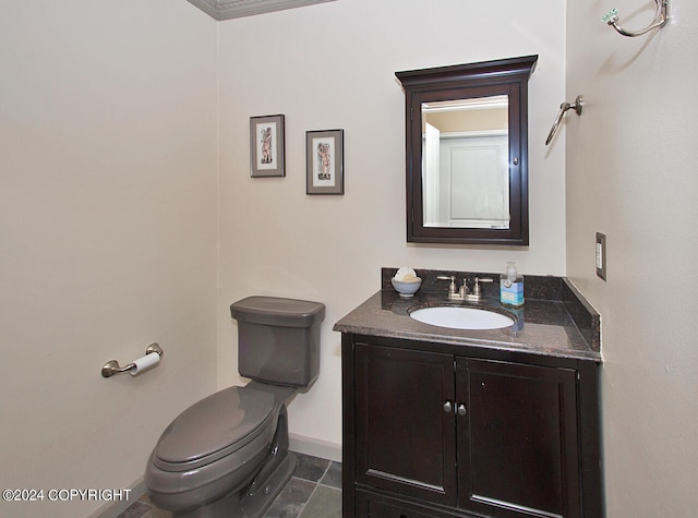 bathroom featuring tile patterned flooring, toilet, vanity, and ornamental molding