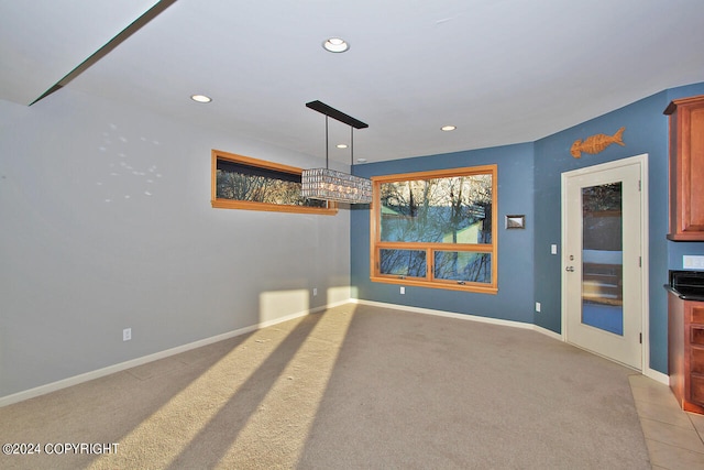 unfurnished dining area featuring light colored carpet