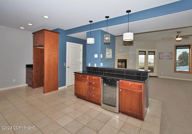 kitchen featuring french doors, light carpet, ceiling fan, beverage cooler, and hanging light fixtures