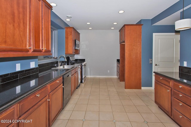 kitchen featuring decorative light fixtures, stainless steel appliances, sink, light tile patterned floors, and dark stone counters