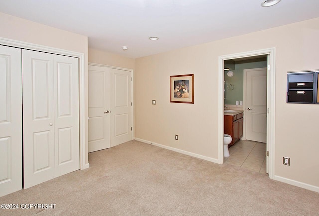928 Quiet Creek Dr, Homer, AK 99603 - unfurnished bedroom featuring light colored carpet, baseboards, ensuite bath, a sink, and a closet