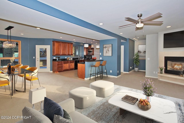 carpeted living room featuring sink and ceiling fan