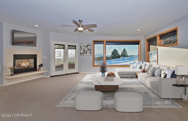 carpeted living room featuring ceiling fan, french doors, and a tile fireplace