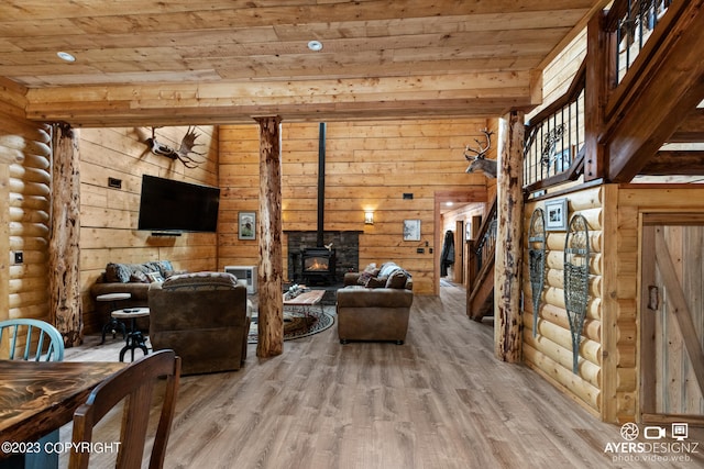 living room with log walls, wooden ceiling, a wood stove, and light wood-type flooring