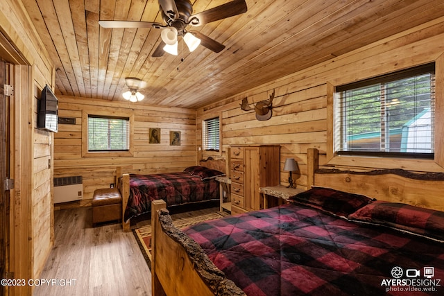 bedroom featuring wooden walls, wooden ceiling, wood-type flooring, and ceiling fan