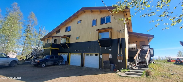 9450 Keshon Cir, Wasilla, AK 99654 - view of building exterior featuring stairway, a garage, and asphalt driveway