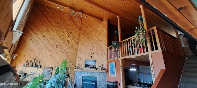 9450 Keshon Cir, Wasilla, AK 99654 - living area featuring a high ceiling, stairs, wooden walls, and a tiled fireplace