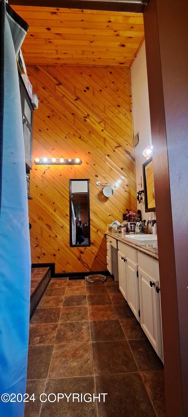 9450 Keshon Cir, Wasilla, AK 99654 - bathroom featuring wood walls, vanity, wood ceiling, and stone finish floors