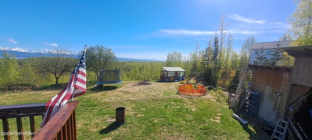 9450 Keshon Cir, Wasilla, AK 99654 - view of grassy yard featuring a trampoline and an outdoor structure