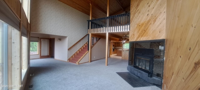 9450 Keshon Cir, Wasilla, AK 99654 - unfurnished living room featuring high vaulted ceiling, carpet, a fireplace, stairs, and wood ceiling