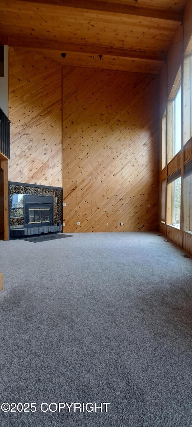 9450 Keshon Cir, Wasilla, AK 99654 - unfurnished living room featuring high vaulted ceiling, a fireplace, wooden ceiling, carpet, and wooden walls