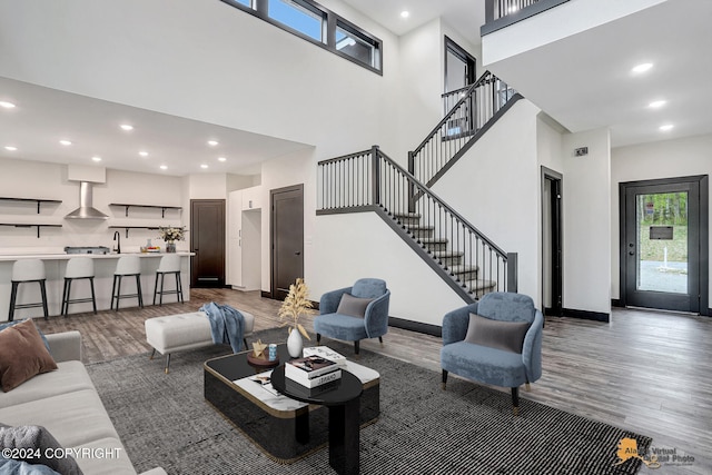 living room featuring hardwood / wood-style flooring and a towering ceiling