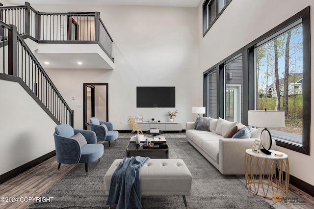 living room with plenty of natural light, hardwood / wood-style floors, and a high ceiling