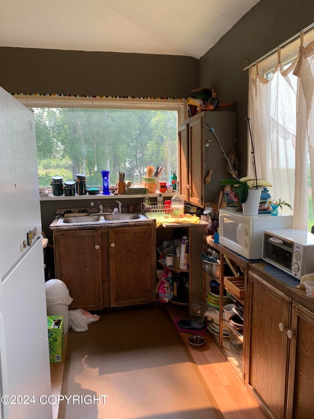 kitchen with light hardwood / wood-style floors, white appliances, and sink