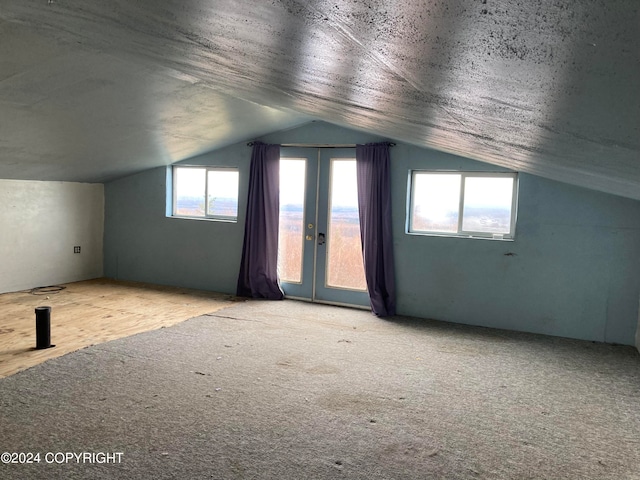 bonus room featuring french doors, lofted ceiling, and carpet flooring