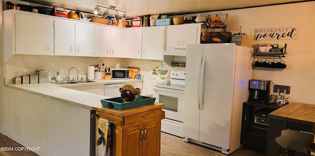 kitchen with white appliances, white cabinetry, light hardwood / wood-style floors, and sink