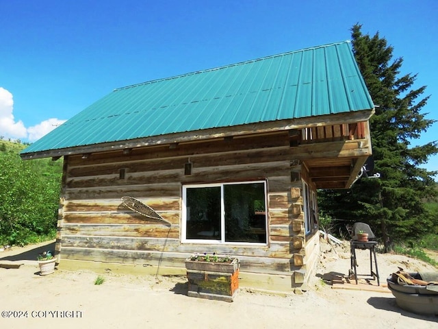 exterior space featuring metal roof and log siding