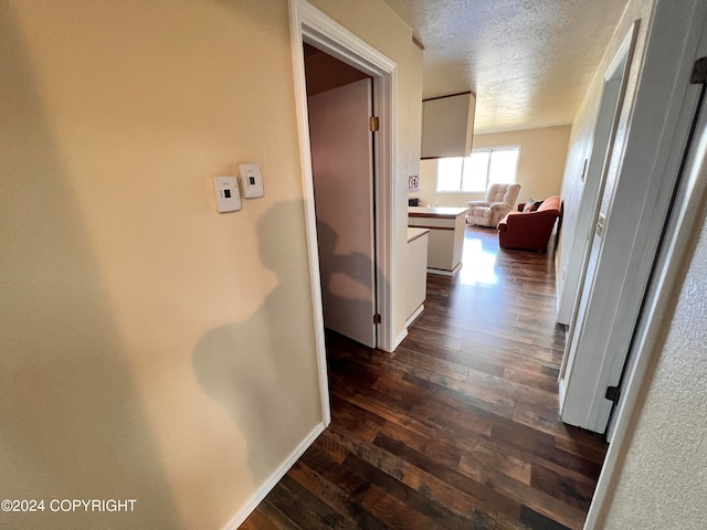 hall with hardwood / wood-style floors and a textured ceiling