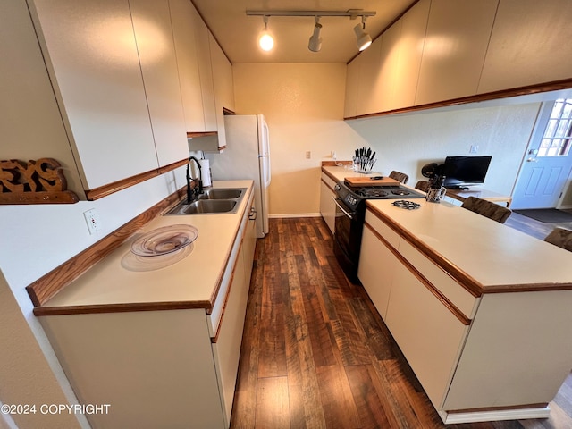 kitchen with white fridge, black range, sink, dark hardwood / wood-style floors, and track lighting