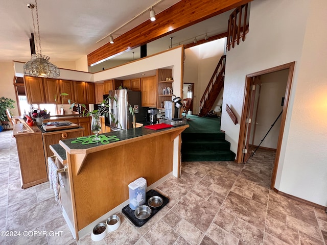 kitchen with rail lighting, light tile patterned floors, kitchen peninsula, pendant lighting, and stainless steel fridge