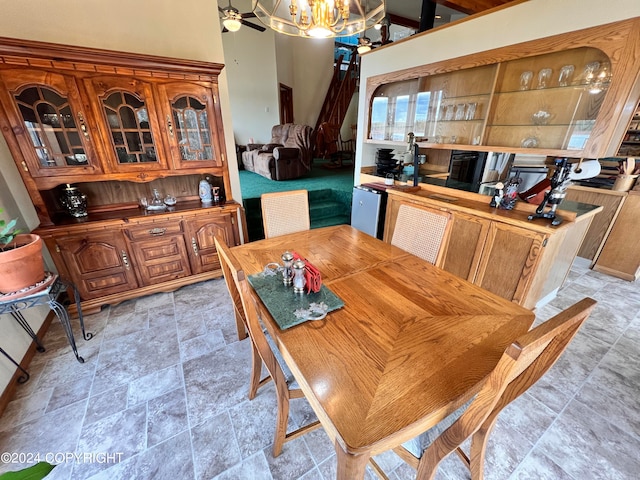 dining space with ceiling fan with notable chandelier and light tile patterned floors