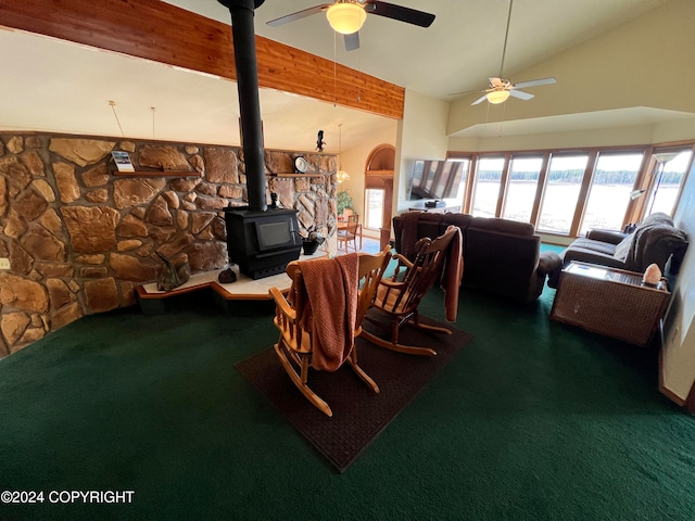 dining space with a wood stove, carpet, lofted ceiling, and ceiling fan