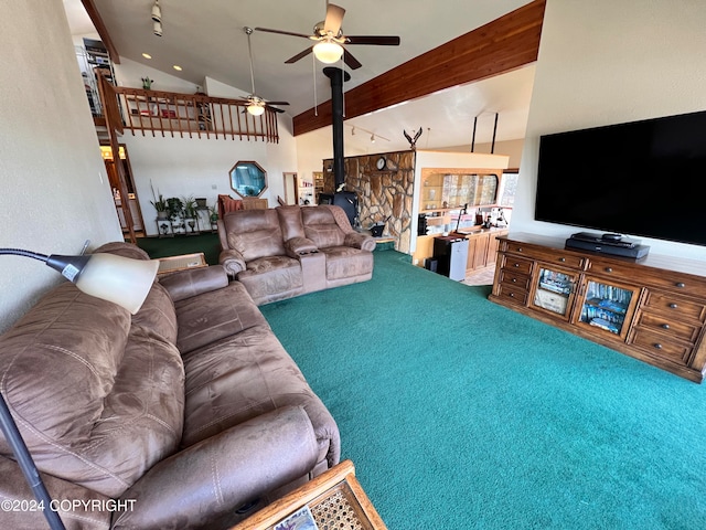 carpeted living room with a wood stove, beamed ceiling, high vaulted ceiling, and ceiling fan