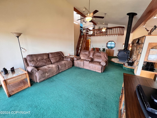 carpeted living room with high vaulted ceiling, ceiling fan, beam ceiling, and a wood stove