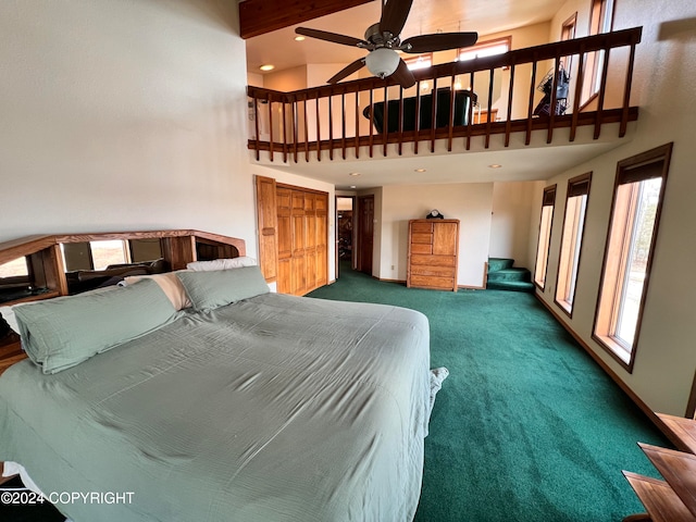 carpeted bedroom with a high ceiling and ceiling fan