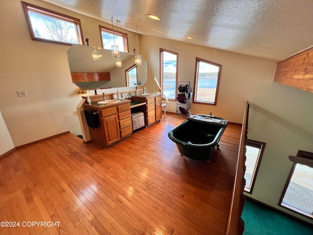 living room with a textured ceiling, sink, and wood-type flooring