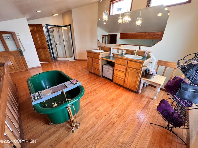 kitchen featuring light hardwood / wood-style floors, sink, decorative light fixtures, and a notable chandelier