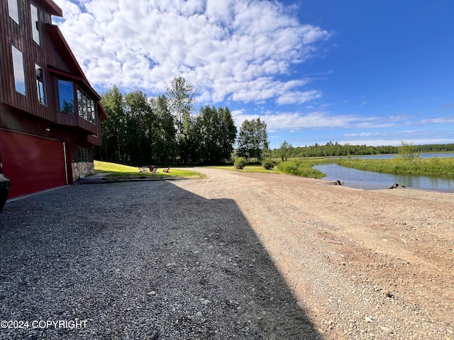 view of yard with a garage and a water view