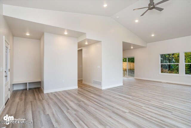 spare room featuring plenty of natural light, high vaulted ceiling, light wood-type flooring, and ceiling fan