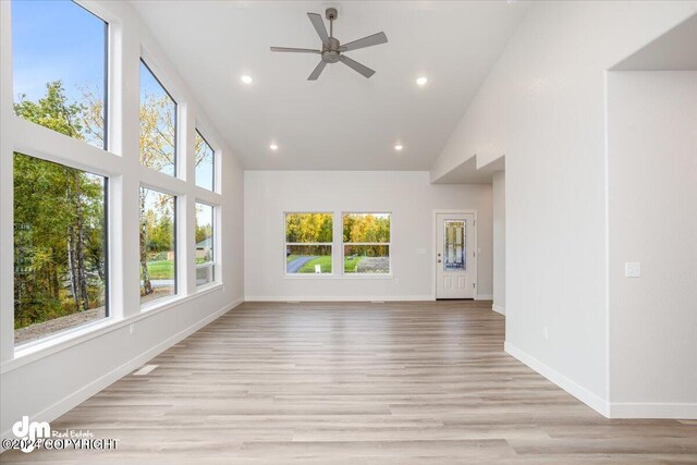 unfurnished living room with high vaulted ceiling, light hardwood / wood-style flooring, and ceiling fan