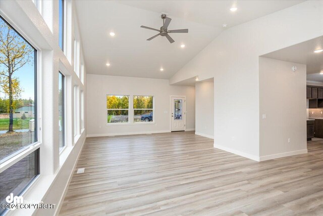 unfurnished living room featuring ceiling fan, light hardwood / wood-style flooring, and high vaulted ceiling