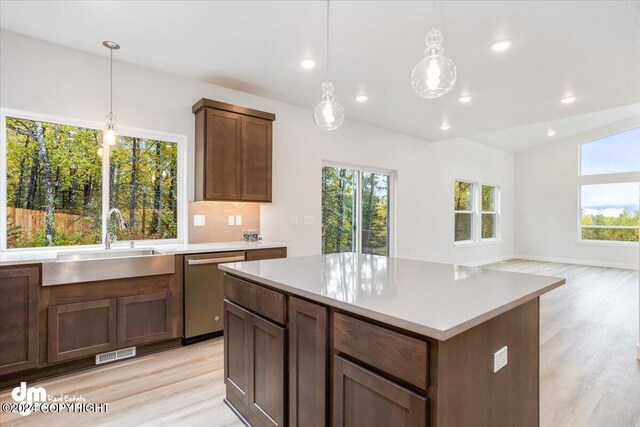 kitchen with decorative light fixtures, stainless steel dishwasher, and a healthy amount of sunlight