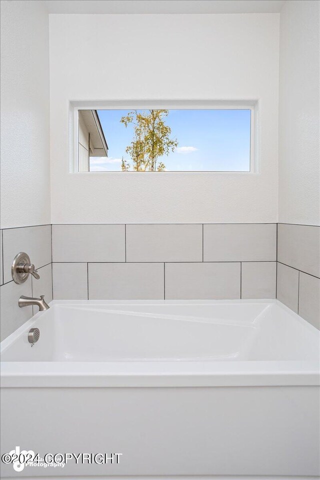 bathroom with plenty of natural light and a bath