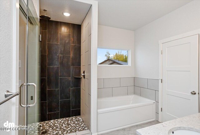 bathroom featuring a textured ceiling, plus walk in shower, and tile patterned floors