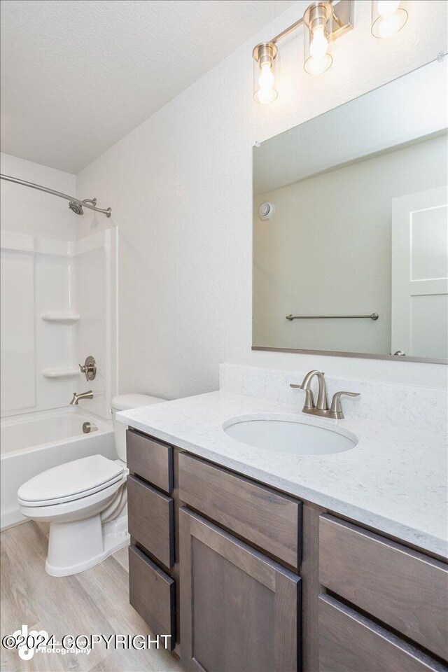 full bathroom featuring tub / shower combination, hardwood / wood-style floors, vanity, and toilet