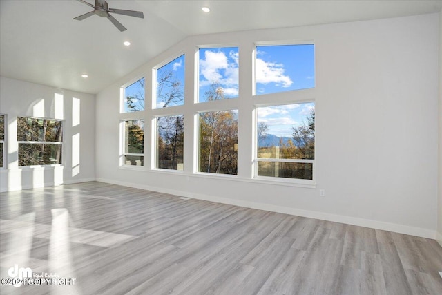 unfurnished sunroom featuring a healthy amount of sunlight, ceiling fan, and vaulted ceiling