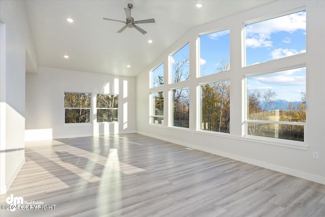 unfurnished sunroom featuring ceiling fan, lofted ceiling, and a healthy amount of sunlight