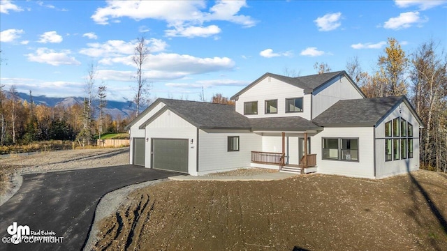 view of front of house featuring a mountain view, covered porch, and a garage