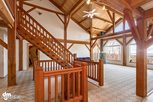 interior space featuring beamed ceiling, wooden ceiling, high vaulted ceiling, carpet, and ceiling fan