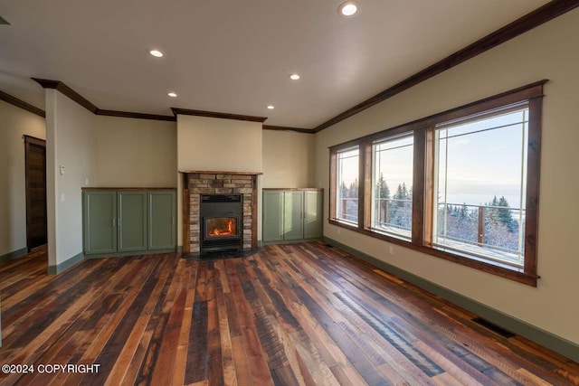 unfurnished living room featuring a stone fireplace, crown molding, and dark hardwood / wood-style flooring