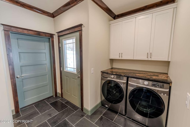 laundry room featuring washer and clothes dryer, cabinets, and ornamental molding