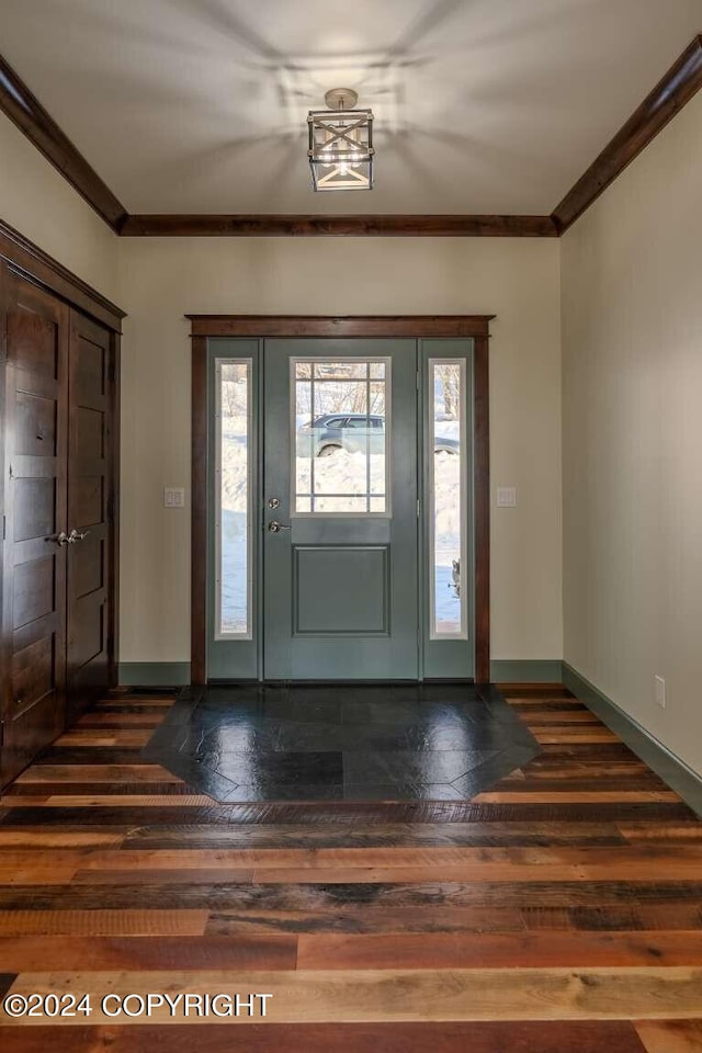 foyer entrance featuring crown molding and dark wood-type flooring