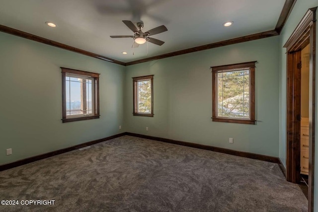 unfurnished bedroom with crown molding, dark colored carpet, multiple windows, and ceiling fan