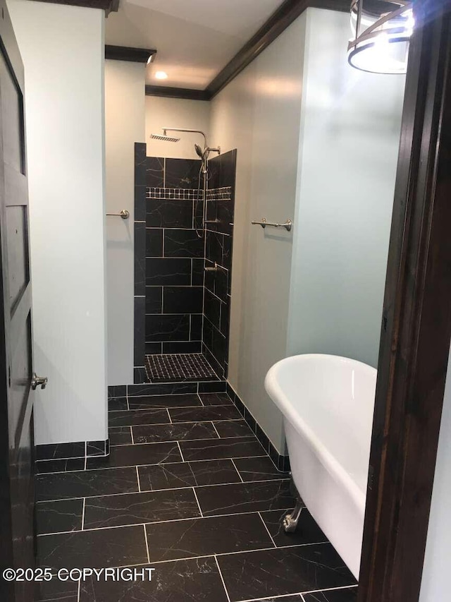 bathroom with marble finish floor, a stall shower, a freestanding tub, and crown molding