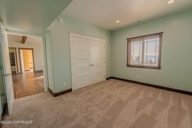 unfurnished bedroom featuring recessed lighting, baseboards, a closet, and light colored carpet