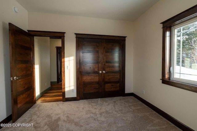 unfurnished bedroom with baseboards and dark colored carpet